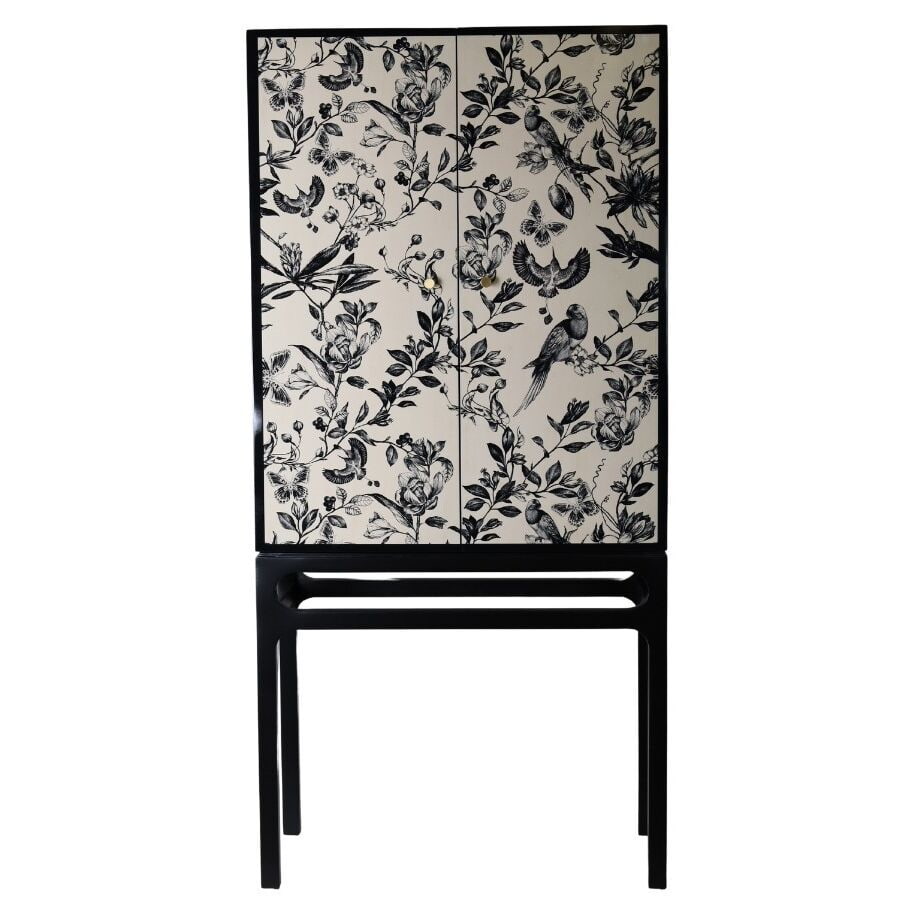 Szafka w kolorze czarno-beżowym na metalowej podstawie ze złotymi uchwytami dwudrzwiowa w kwiatowy wzór